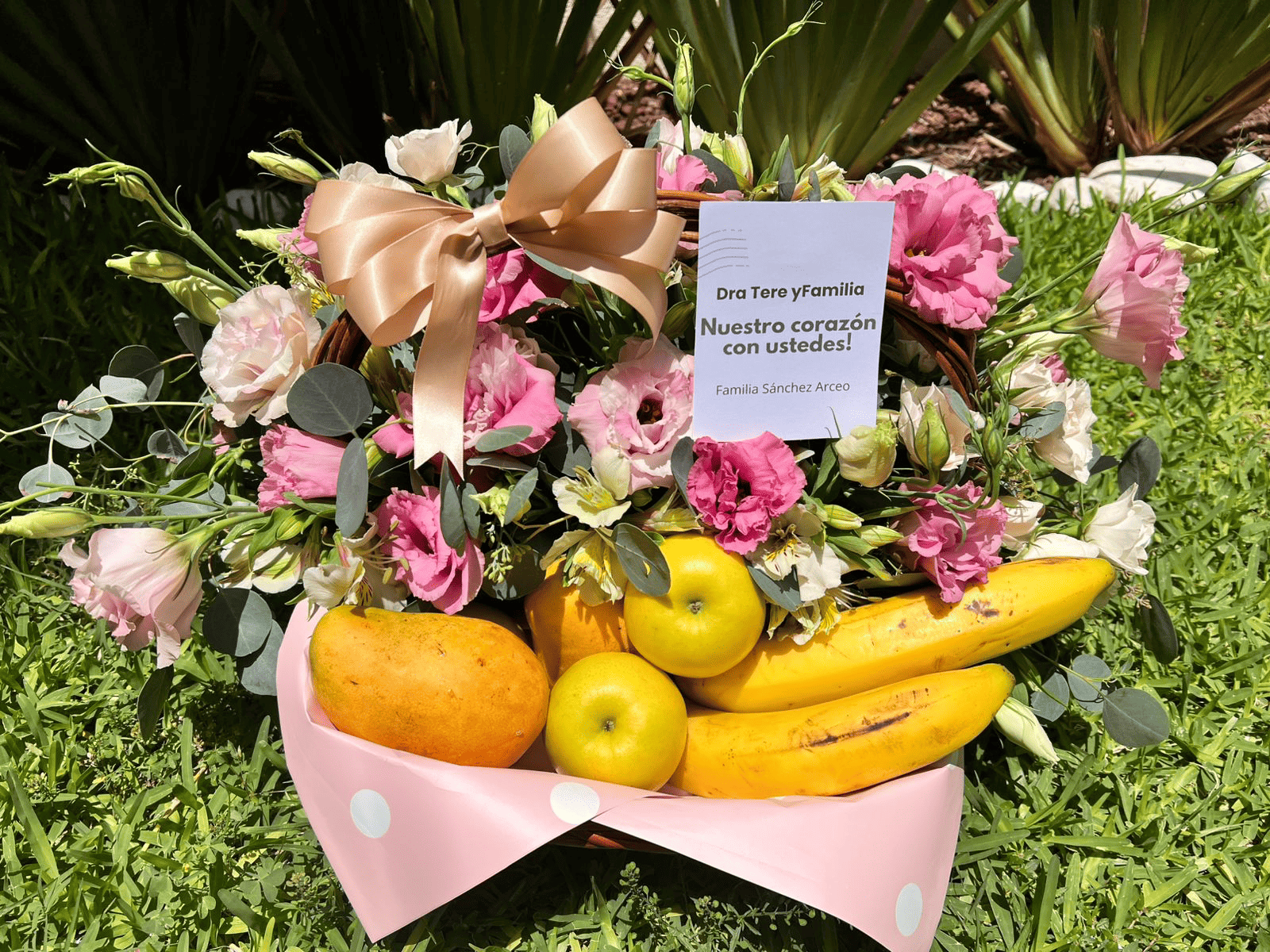Canasta con flores rosas y frutas